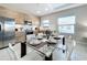 Modern dining area with glass-top table, seating for six, and an open layout connected to kitchen at 185 Brookes Pl, Haines City, FL 33844