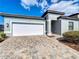 Charming one-story home featuring a brick driveway, two-car garage, and well-maintained landscaping at 185 Brookes Pl, Haines City, FL 33844