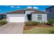 Charming one-story home featuring a brick driveway, two-car garage, and well-maintained landscaping at 185 Brookes Pl, Haines City, FL 33844