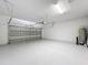 Spacious garage with an automatic door, white painted walls, and plenty of room for parking and storage at 185 Brookes Pl, Haines City, FL 33844