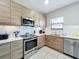 Modern kitchen with stainless steel appliances, sleek wood cabinets, and white countertops at 185 Brookes Pl, Haines City, FL 33844