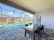 Inviting covered patio with a dining table, offering a serene view of the pool and outdoor living space at 185 Brookes Pl, Haines City, FL 33844