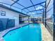 Beautiful pool with blue tile accents and a full screen enclosure, offering a private outdoor retreat at 185 Brookes Pl, Haines City, FL 33844