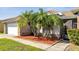 Exterior view of a home with a well-manicured lawn and palm trees at 2351 Oldfield Dr, Orlando, FL 32837