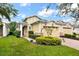 Tan two-car garage villa with red door and landscaped yard at 2453 Yellow Brick Rd, St Cloud, FL 34772