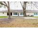 Back exterior view of home with several windows, sliding glass doors and mature trees at 2724 Shelby Ruth Pl, Saint Cloud, FL 34769
