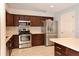 Modern kitchen featuring stainless steel appliances, dark cabinets, light countertops, and a tile backsplash at 2724 Shelby Ruth Pl, Saint Cloud, FL 34769