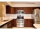 Modern kitchen featuring stainless steel appliances, dark cabinets, light countertops, and a tile backsplash at 2724 Shelby Ruth Pl, Saint Cloud, FL 34769