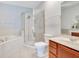 Well-lit bathroom featuring a bathtub with shower and a wood vanity with sink and mirror at 2106 Chatham Place Dr, Orlando, FL 32824
