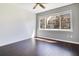 A sunny bedroom with hardwood floors and a large window overlooking the exterior at 2106 Chatham Place Dr, Orlando, FL 32824