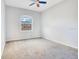 A simple bedroom features neutral walls, carpet, and a window letting in natural light at 2106 Chatham Place Dr, Orlando, FL 32824
