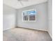 A simple bedroom features neutral walls, carpet, and a window letting in natural light at 2106 Chatham Place Dr, Orlando, FL 32824