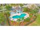 An aerial view shows a sparkling community pool surrounded by lush landscaping and lounge chairs at 2106 Chatham Place Dr, Orlando, FL 32824