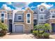 Stylish townhome exterior with a brick driveway, lush landscaping and a two-car garage at 2106 Chatham Place Dr, Orlando, FL 32824