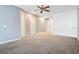 Spacious living room with neutral carpet, ceiling fan, and freshly painted light grey walls at 2106 Chatham Place Dr, Orlando, FL 32824