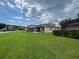 A well-manicured backyard features a screened-in patio with beautiful lawn and landscaping at 4980 W Castle W St, Kissimmee, FL 34758