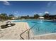 Resort-style pool with fountain feature, surrounded by palm trees, sun loungers and lush landscaping at 4980 W Castle W St, Kissimmee, FL 34758