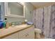 Bathroom featuring granite countertop vanity, framed mirror, and marble look shower curtain at 19529 Dorr Rd, Altoona, FL 32702