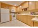Kitchen featuring wood cabinets, white appliances, and light-colored countertops at 19529 Dorr Rd, Altoona, FL 32702