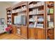 Cherry-stained built in bookcase with tv, cabinets, drawers, and glass doors at 19529 Dorr Rd, Altoona, FL 32702