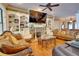 Elegant living room features a fireplace, custom built-ins, wood floors, and a ceiling fan at 19529 Dorr Rd, Altoona, FL 32702