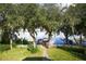 Picturesque waterfront view featuring a private dock and boat lift, surrounded by lush greenery at 19529 Dorr Rd, Altoona, FL 32702