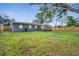Backyard view of a house with a lawn, patio, and wood fence under a blue sky at 1318 Terre Cia Ave, Orlando, FL 32807