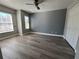 Bedroom featuring wood-look flooring, two windows with blinds, and a closet at 13330 Briar Forest Ct, Orlando, FL 32828