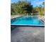 Refreshing outdoor pool with clear blue water, surrounded by trees at 2647 Surrey Ct # 2647, Kissimmee, FL 34741