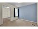 Well-lit bedroom with carpeted floors and a blue accent wall next to mirror closet at 3145 Britannia Blvd # D, Kissimmee, FL 34747