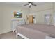 Bedroom with a white bed frame, neutral walls, ceiling fan, TV, and ensuite bathroom at 3145 Britannia Blvd # D, Kissimmee, FL 34747
