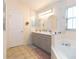 Bathroom with a double sink vanity, large mirrors, a garden tub, and tile flooring at 162 Seneca Point Trl, Kissimmee, FL 34746