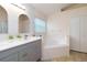 Bright bathroom featuring a double sink vanity, garden tub, tile flooring, and soft neutral paint at 162 Seneca Point Trl, Kissimmee, FL 34746