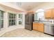 Corner kitchen with stainless steel appliances, tile flooring, and sunlit windows at 162 Seneca Point Trl, Kissimmee, FL 34746