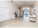 Open-plan living room with a vaulted ceiling, tile floors, and access to the outdoor patio at 162 Seneca Point Trl, Kissimmee, FL 34746