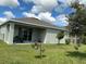 Wide backyard with grass, tree, landscaping and covered patio at 4183 Cortland Dr, Davenport, FL 33837