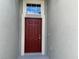Inviting front entrance featuring a bold red door with decorative trim and a transom window for added light at 4183 Cortland Dr, Davenport, FL 33837