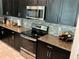 Modern kitchen design featuring stainless steel appliances, dark cabinetry, and elegant granite countertops at 4183 Cortland Dr, Davenport, FL 33837