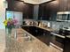 This kitchen features stainless steel appliances, granite countertops, and dark wood cabinetry for a modern look at 4183 Cortland Dr, Davenport, FL 33837