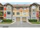 A colorful condo building with two garages underneath each unit and well manicured shrubbery at 2217 Grand Cayman Ct # 1233, Kissimmee, FL 34741