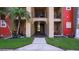 Well-maintained building exterior with tropical landscaping, covered entryways, and lush green grass at 2217 Grand Cayman Ct # 1233, Kissimmee, FL 34741