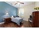 Bedroom featuring a blue accent wall, hardwood floors, and natural light from the window at 3222 Stonehurst Cir, Kissimmee, FL 34741