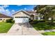 Charming single-story home with a well-maintained lawn and a two-car garage on a sunny day at 3222 Stonehurst Cir, Kissimmee, FL 34741