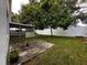 View of the backyard featuring a white fence, a screened-in patio, and a mature shade tree at 5906 Rywood Dr, Orlando, FL 32810