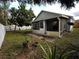 Landscaped backyard featuring a screened-in patio and mature tree, surrounded by a well-maintained fence at 5906 Rywood Dr, Orlando, FL 32810