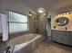 Luxurious bathroom featuring a soaking tub, a separate shower, and a modern vanity with stylish fixtures at 5906 Rywood Dr, Orlando, FL 32810
