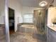 Bright bathroom with separate shower and tub, gray tiled floor, and view of the main bedroom at 5906 Rywood Dr, Orlando, FL 32810