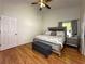 Comfortable bedroom with hardwood floors, a ceiling fan, and a king-size bed with stylish furnishings at 5906 Rywood Dr, Orlando, FL 32810