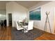 Modern dining room with glass table, white chairs, wood floors, and stylish wall art at 5906 Rywood Dr, Orlando, FL 32810