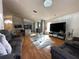 Open concept living room and kitchen with hardwood floors, modern furnishings, and natural light at 5906 Rywood Dr, Orlando, FL 32810